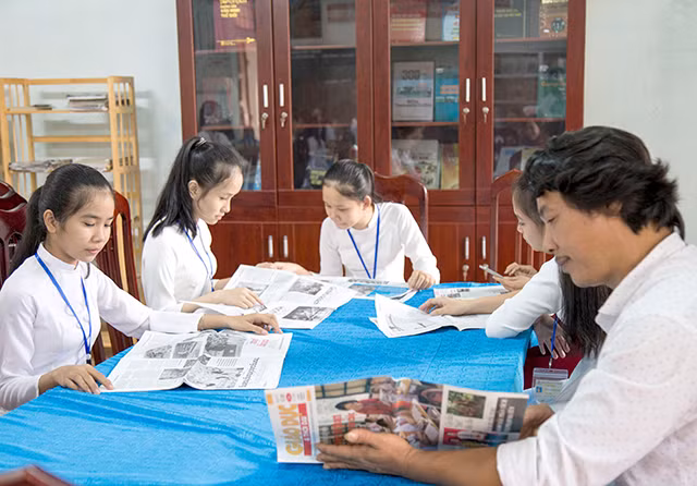 Thầy giáo và học sinh trường trường THCS&THPT Việt Trung tham gia đọc sách báo tại thư viện