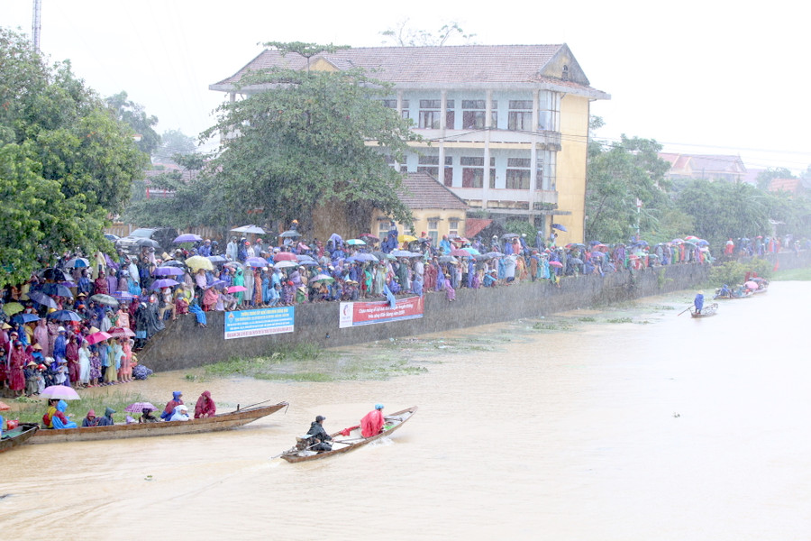 Các cổ động viên nhiệt tình đội mưa cổ vũ cho các đội đua, bơi...