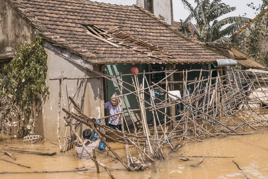Một căn nhà bị nước lũ làm sập giàn mát trước sân chắn cả lối đi