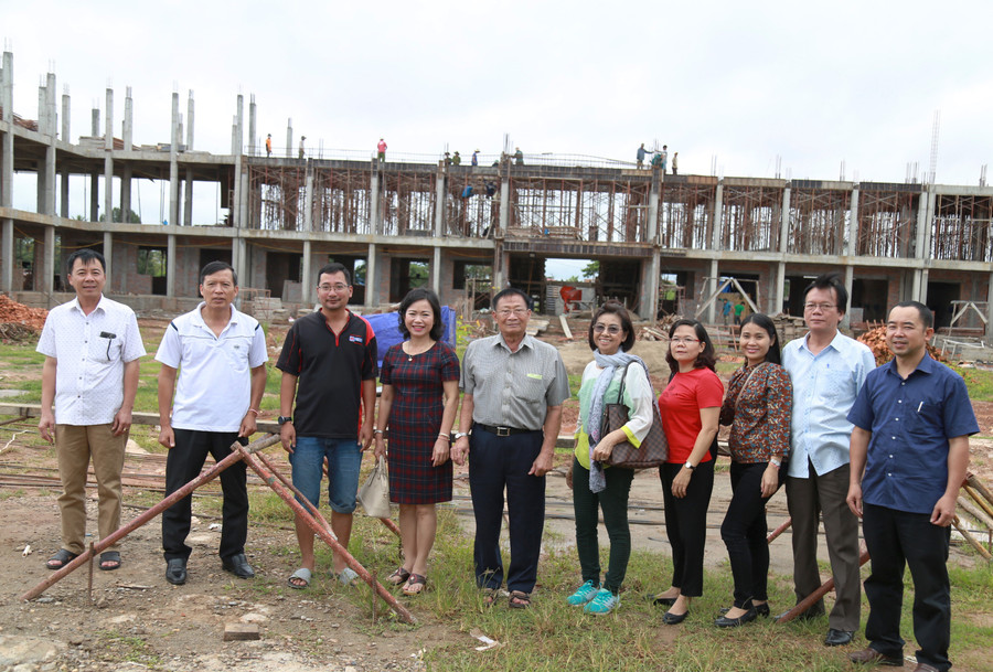 Hội Việt Kiều và đại diện ngành GD&ĐT tỉnh Quảng Trị chụp ảnh tại ngôi trường có giá trị hơn 2 triệu USD đang xây dựng được chính quyền tỉnh Savannakhet đầu tư dành cho con em Việt kiều đang sinh sống tại Savannakhet