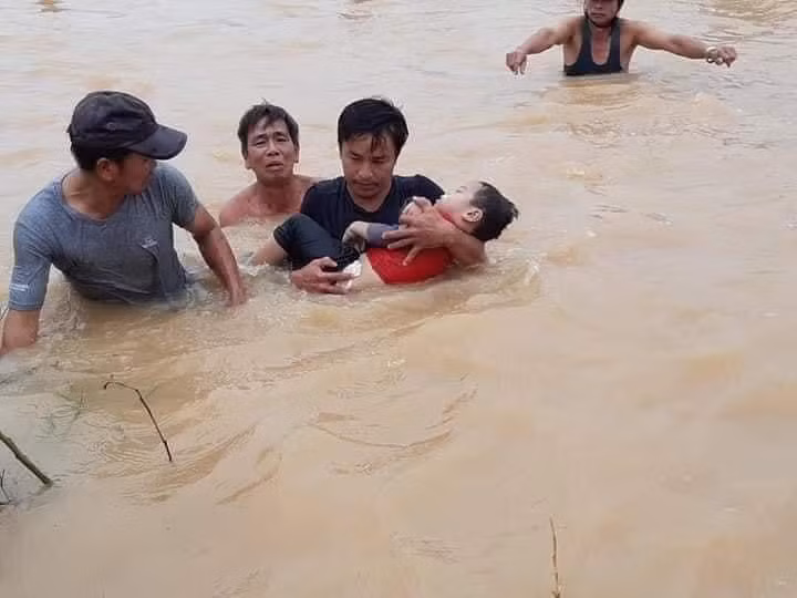 Bế trẻ... chạy lũ