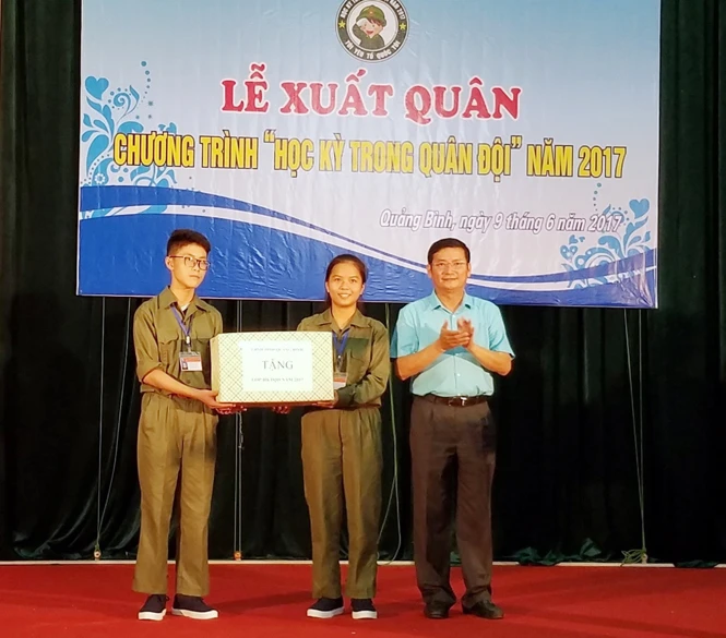 Ông Trần Tiến Dũng, Phó chủ tịch UBND tỉnh Quảng Bình tặng quà cho các em học sinh tham dự khoá học trong lễ xuất quân (Ảnh Lan Chi)