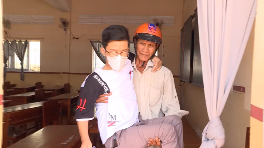 Ông Phạm Văn Út bồng con đến phòng thi ở mỗi buổi thi.