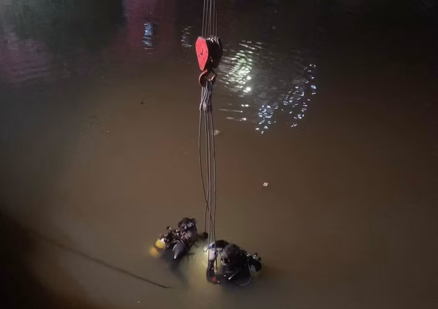 Lực lượng chức năng tiến hành trục vớt phương tiện tai nạn lên bờ.