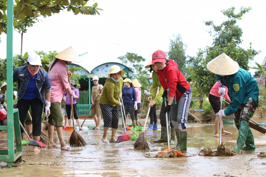 Giáo viên Trường mầm non Liên Thuỷ dọn bùn ra khỏi trường