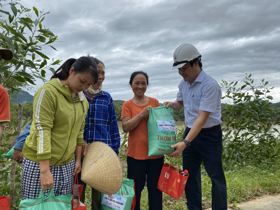 Đại diện công ty Điện lực Quảng Bình tặng quà cho bà con khó khăn.