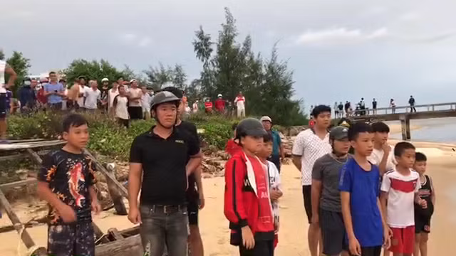 Người dân đứng chờ tàu đưa thi thể anh Khoa vào bờ (Ảnh cắt từ clip).