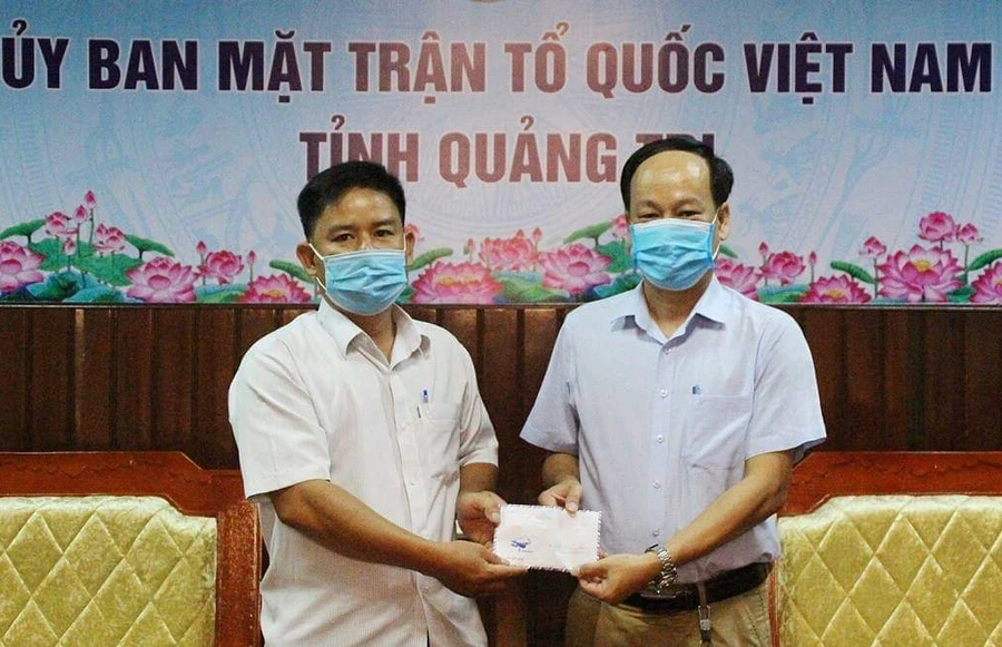 Thầy Tước (bên trái) trao tặng lại số tiền thưởng của mình cho quỹ phòng, chống Covid-19 của Quảng Trị.