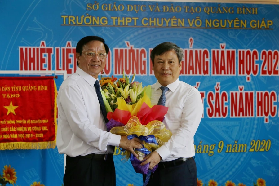 Ông Vũ Đại Thắng (phải) tặng hoa nhân ngày khai giảng năm học mới cho lãnh đạo Trường THPT Chuyên Võ Nguyên Giáp.