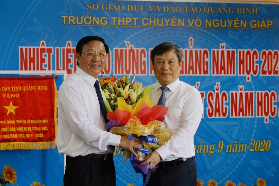 Ông Vũ Đại Thắng (phải) tặng hoa nhân ngày khai giảng năm học mới cho lãnh đạo Trường THPT Chuyên Võ Nguyên Giáp.