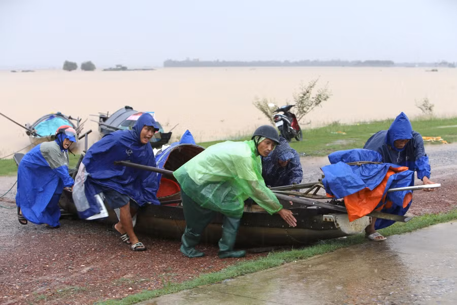 Người dân đưa thuyền nhỏ lên bờ tránh lũ