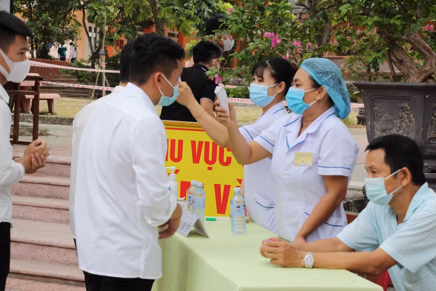Các thí sinh được đo thân nhiệt và sát khuẩn tay trước khi vào điểm thi