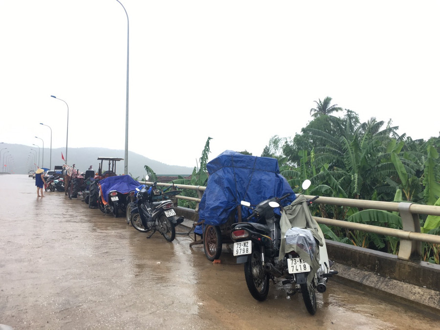 Mang xe máy và đồ dùng lên cầu cao để tránh lũ. Mang xe máy và đồ dùng lên cầu cao để tránh lũ.