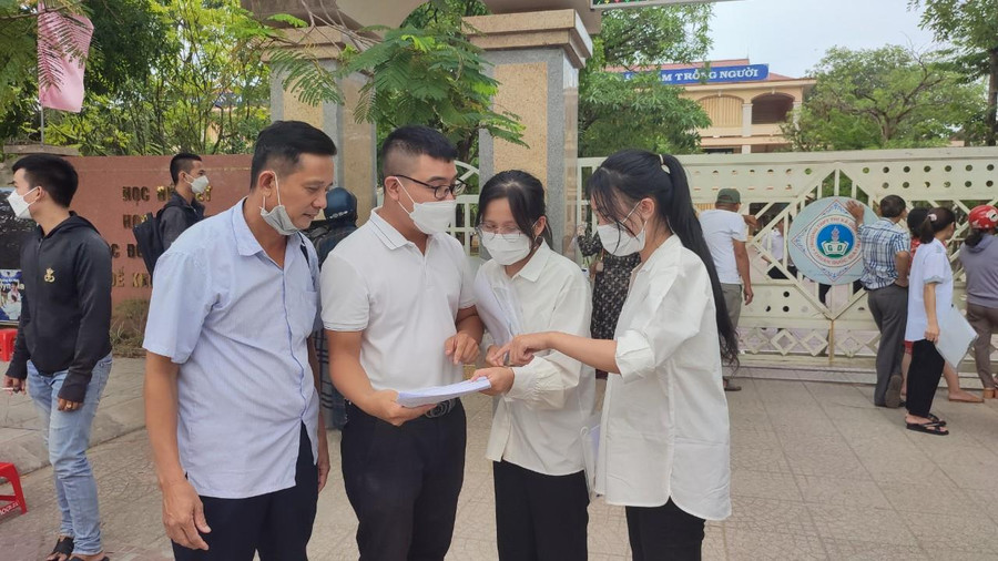 Các thí sinh nán lại trước cổng điểm thi để giải đề thi Toán. Các thí sinh nán lại trước cổng điểm thi để giải đề thi Toán.