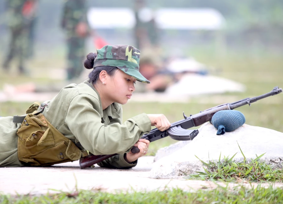 Học sinh kiểm tra súng trước khi bước vào loạt bắn đạn thật.