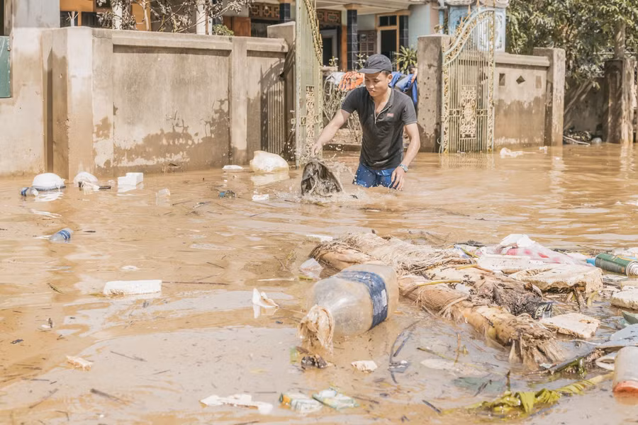 Gom rác và dọn vệ sinh trước cổng nhà