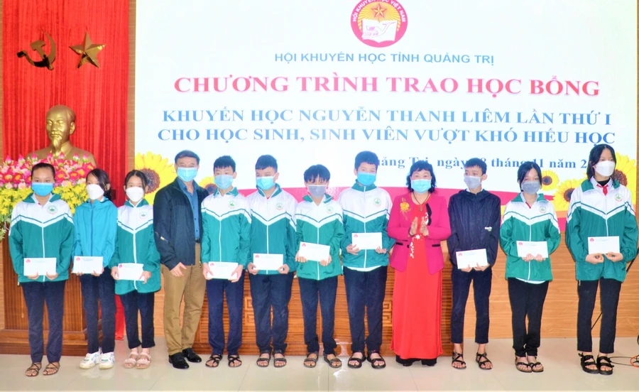 Đại diện Hội khuyến học tỉnh Quảng Trị trao các suất học bổng cho học sinh, sinh viên có hoàn cảnh khó khăn. Ảnh: SH