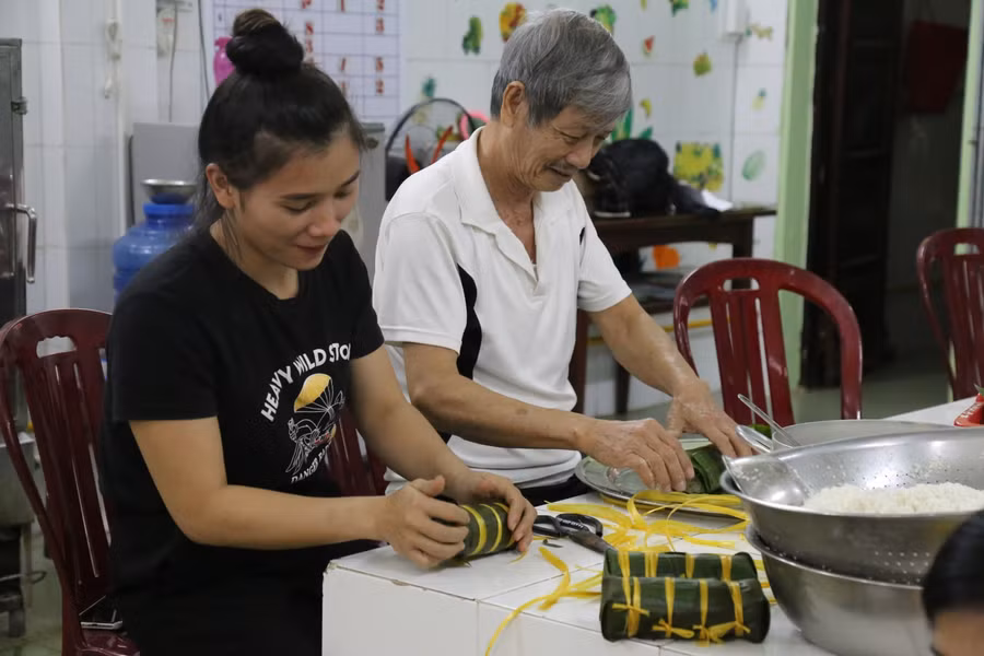 Nhiều giáo viên được người dân vừa làm vừa hướng dẫn cách gói bánh Tét.