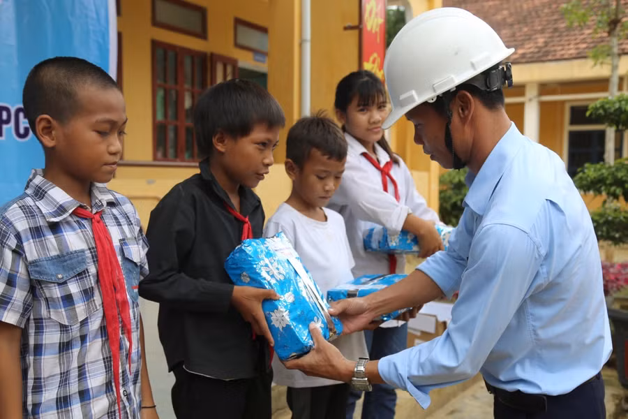 Đại diện Công ty Điện lực Quảng Bình tặng quà cho học sinh vùng khó.