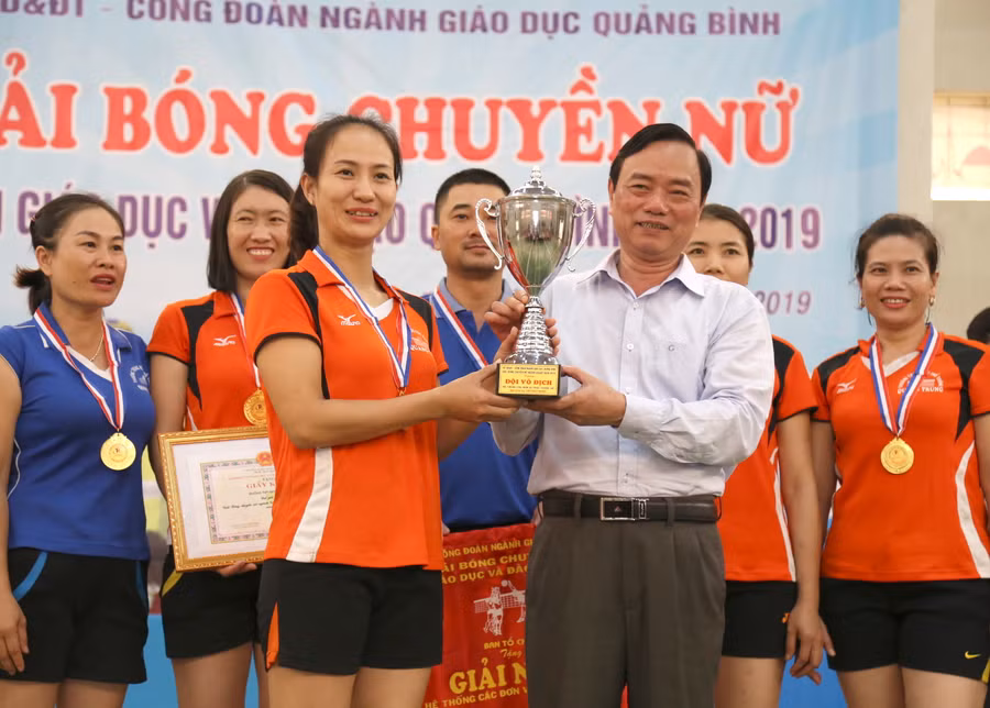 Ông Đinh Quý Nhân, giám đốc Sở GD&ĐT trao cờ, cúp vô địch cho đội bóng chuyền nữ trường THPT Quang Trung vô địch khối trực thuộc Sở.