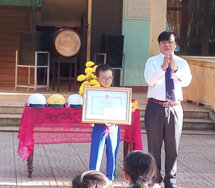 Thừa uỷ quyền của Bộ trưởng Bộ GD&ĐT Phùng Xuân Nhạ, đại diện ngành GD&ĐT tỉnh Quảng Trị trao bằng khen cho học sinh Hoàng Đức Sơn - tấm gương vượt khó vươn lên trong học tập.