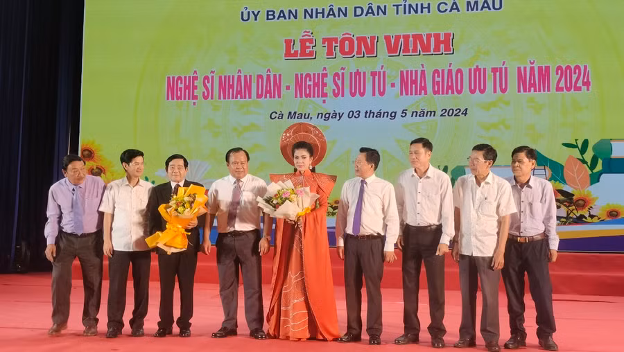2 Nghệ sĩ Nhân dân (người cầm hoa) chụp ảnh lưu niệm cùng lãnh đạo tỉnh
