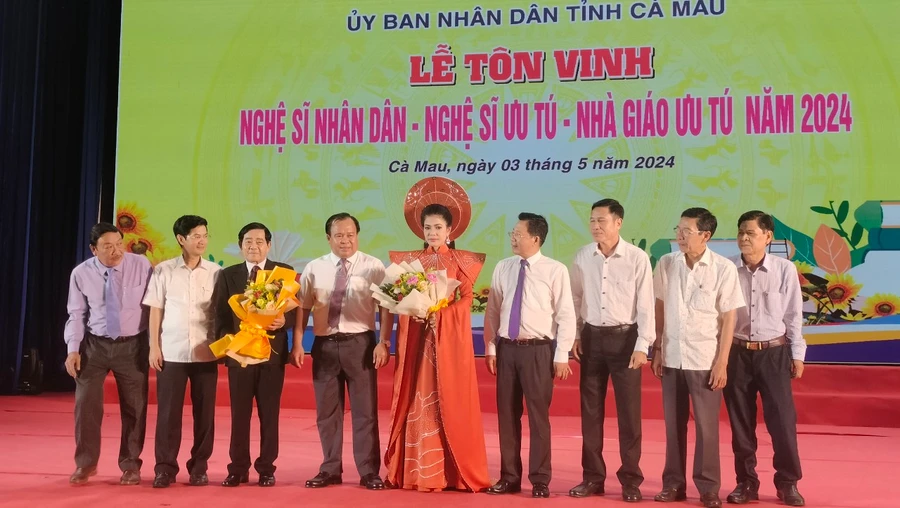 2 Nghệ sĩ Nhân dân (người cầm hoa) chụp ảnh lưu niệm cùng lãnh đạo tỉnh