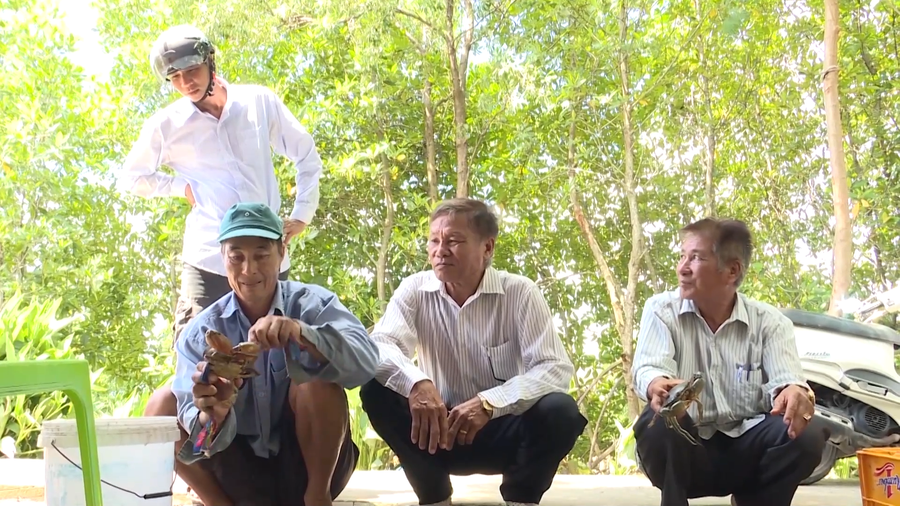 Ông Việt chia sẻ kinh nghiệm nuôi cua với người dân trong ấp.