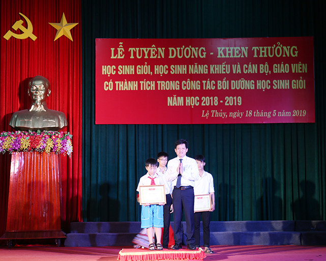 Ông Lê Văn Bảo, Bí thư huyện uỷ trao giấy khen cho em Lê Văn Thái Sơn đạt giải cao trong kỳ thi Tài năng tiếng Anh cấp tỉnh và Trạng nguyên tiếng anh toàn quốc và xuất sắc nhận suất học bổng trị giá 1,5 tỷ đồng.