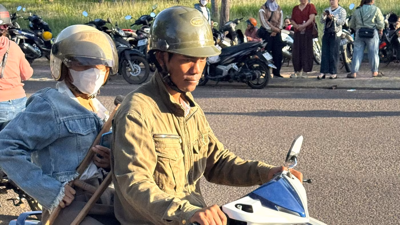 Chị Đinh Thị Dách được chồng chở đến điểm thi.