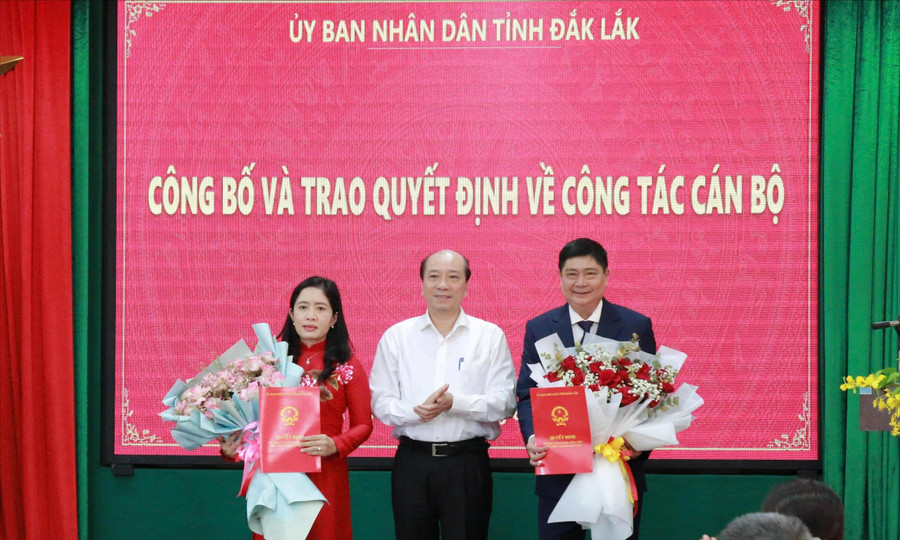 Chủ tịch UBND tỉnh Đắk Lắk Phạm Ngọc Nghị trao quyết định, tặng hoa cho nguyên và tân Giám đốc Sở GD&ĐT. (Ảnh: Thành Tâm)