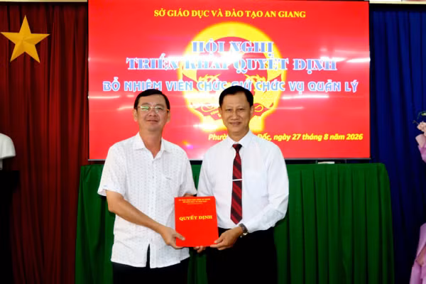 Ông Cao Quốc Điện (trái), Phó Giám đốc Sở Giáo dục và Đào tạo tỉnh An Giang, trao Quyết định bổ nhiệm ông Trần Quốc Vũ.