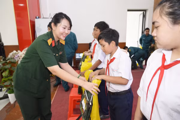 Đại diện Hội Phụ nữ cơ quan Bộ CHQS tỉnh An Giang trao quà cho học sinh có hoàn cảnh khó khăn vươn lên học giỏi.