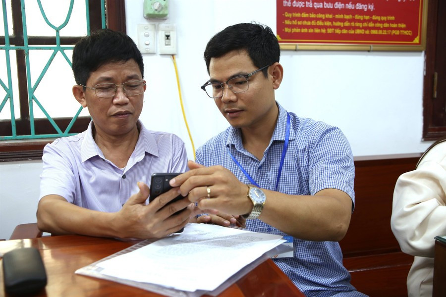 Cán bộ xã Ý Yên hướng dẫn người dân sử dụng dịch vụ công trực tuyến.