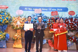 Thay mặt lãnh đạo Bộ GD&ĐT, Thứ trưởng Hoàng Minh Sơn trao quyết định công nhận Hiệu trưởng Trường ĐH Giao thông vận tải đối với PGS.TS Nguyễn Văn Hùng (bìa trái). Ảnh: Đình Tuệ.