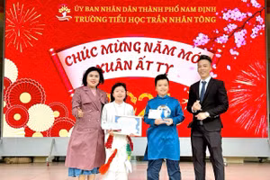 Thầy Vũ Văn Bền (bìa phải) cùng lãnh đạo nhà trường trao thưởng cho học sinh. Ảnh: NVCC.