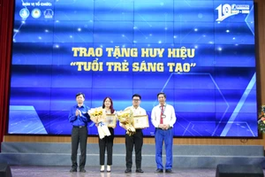 Anh Nguyễn Minh Triết (bìa trái) - Bí thư Trung ương Đoàn, Chủ tịch Trung ương Hội Sinh viên Việt Nam và Giám đốc Học viện Tài chính Nguyễn Đào Tùng trao tặng huy hiệu "Tuổi trẻ sáng tạo" cho hai sinh viên xuất sắc.