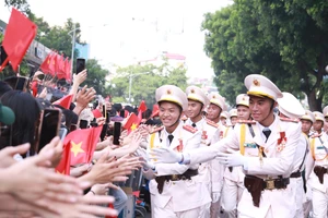 Các chiến sĩ thuộc khối sĩ quan Công an nhân dân giao lưu với người dân hai bên đường tại khu vực cổng Công viên Thống Nhất, Hà Nội sáng 2/9. (Ảnh: Đình Tuệ)