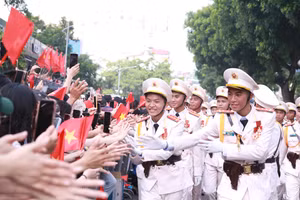 Các chiến sĩ thuộc khối sĩ quan Công an nhân dân giao lưu với người dân hai bên đường tại khu vực cổng Công viên Thống Nhất, Hà Nội sáng 2/9. (Ảnh: Đình Tuệ)