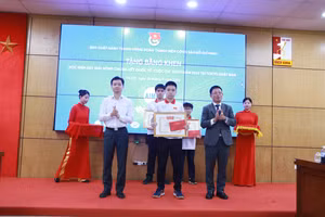 Anh Nguyễn Minh Triết (trái) - Bí thư Trung ương Đoàn, Chủ tịch TW Hội Sinh viên Việt Nam và Tổng Biên tập Báo Tiền phong Phùng Công Sưởng tặng thưởng cho các em học sinh xuất sắc. Ảnh: Đình Tuệ. 