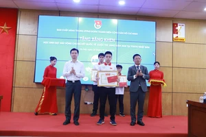Anh Nguyễn Minh Triết (trái) - Bí thư Trung ương Đoàn, Chủ tịch TW Hội Sinh viên Việt Nam và Tổng Biên tập Báo Tiền phong Phùng Công Sưởng tặng thưởng cho các em học sinh xuất sắc. Ảnh: Đình Tuệ. 