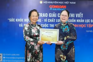 Nguyên Phó Chủ tịch nước Nguyễn Thị Doan (trái) trao giải Nhất cuộc thi viết "Sức khỏe học đường - vì chất lượng nguồn nhân lực đất nước" cho tác giả Trương Thị Mai.
