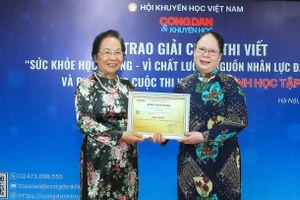 Nguyên Phó Chủ tịch nước Nguyễn Thị Doan (trái) trao giải Nhất cuộc thi viết "Sức khỏe học đường - vì chất lượng nguồn nhân lực đất nước" cho tác giả Trương Thị Mai.