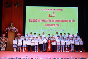 Ông Nguyễn Văn Hưng - Phó Chủ tịch UBND huyện và bà Trần Thị Vân - Chủ tịch Ủy ban MTTQ huyện trao thưởng cho các em học sinh đạt thành tích tiêu biểu năm học vừa qua. 