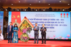 Phó Bí thư Thành ủy Hà Nội Nguyễn Văn Phong (thứ 2 từ phải sang) cùng Giám đốc Sở GD&ĐT Hà Nội Trần Thế Cương tặng hoa chúc mừng thầy trò nhà trường nhân dịp kỷ niệm 40 năm ngày thành lập. 