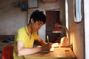 Với chiếc bàn học cũ kĩ dùng nhiều năm, Bùi Nguyên Thủ luôn nỗ lực học tập để theo đuổi ước mơ đại học. Ảnh: Đình Tuệ.