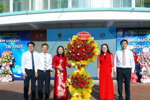 Bà Nguyễn Thị Thanh (thứ hai từ phải qua) - Thường vụ Đảng ủy, Chủ tịch Ủy ban Mặt trận Tổ quốc Việt Nam xã Sơn Đồng tặng hoa chúc mừng nhà trường nhân dịp khai giảng năm học mới. 