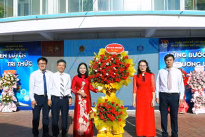 Bà Nguyễn Thị Thanh (thứ hai từ phải qua) - Thường vụ Đảng ủy, Chủ tịch Ủy ban Mặt trận Tổ quốc Việt Nam xã Sơn Đồng tặng hoa chúc mừng nhà trường nhân dịp khai giảng năm học mới. 