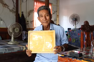 Ông Hữu Minh Út khoe tấm bằng chứng nhận gia đình hiếu học. Ảnh: Quách Mến.