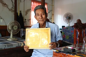 Ông Hữu Minh Út khoe tấm bằng chứng nhận gia đình hiếu học. Ảnh: Quách Mến.